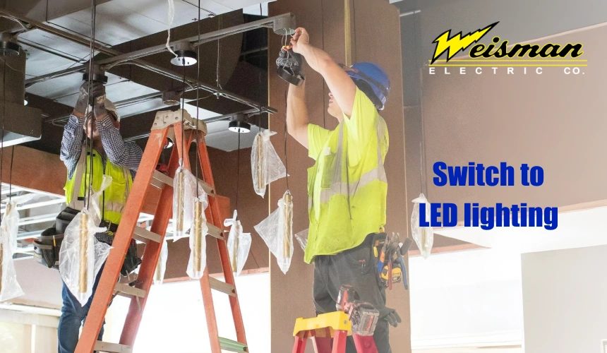 Commercial lighting electrician installing LED fixtures